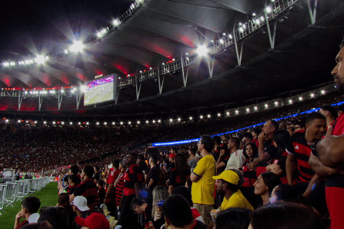 Maracanã iluminado em noite de jogo do Flamengo, com a torcida rubro-negra nas arquibancadas